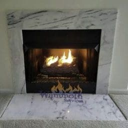 burning gas fireplace with marble surround and hearth